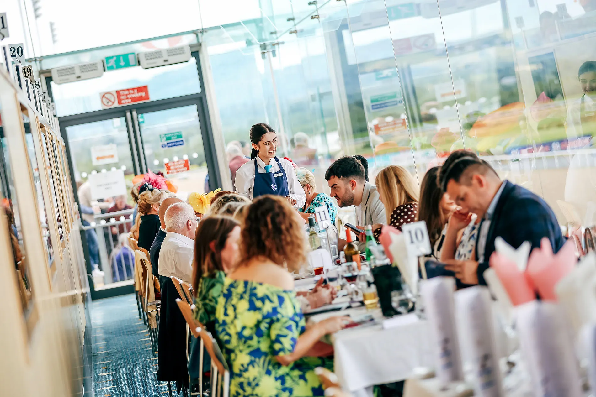 Diners at The View Restaurant with the racetrack through the glass.
