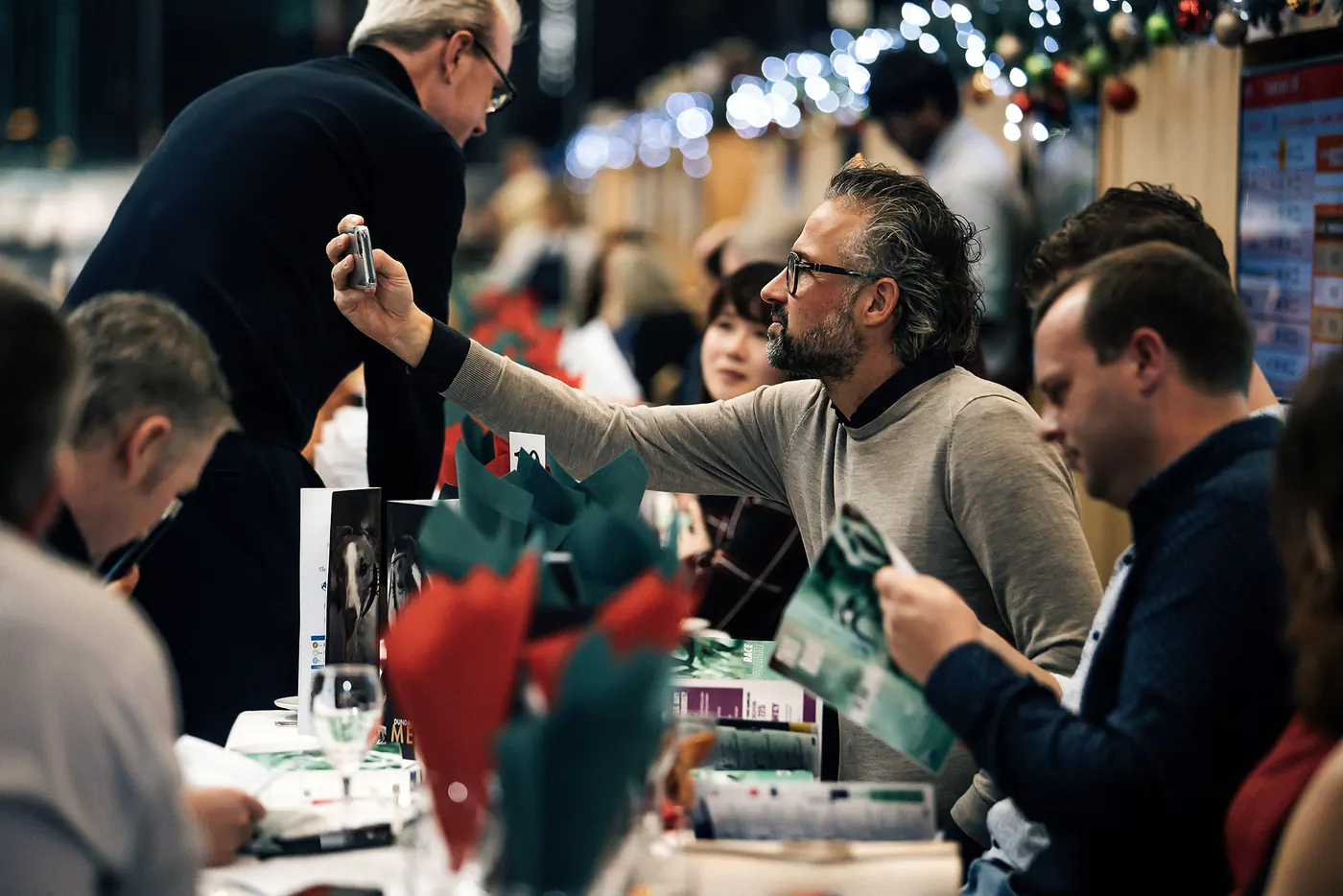 Guests toasting at a Christmas party table.